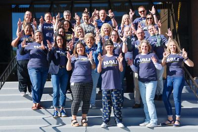 NAU staff posing on the steps of a building and throwing LJs