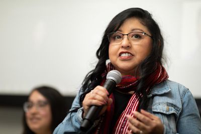 Claudia Rodas speaks into a microphone.