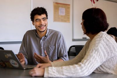 NAU student, Isaiah Raspet, smiles while chatting with his professor.