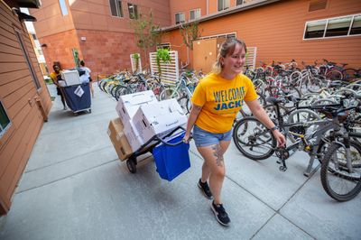 A student on move-in day pulling boxes behind them.
