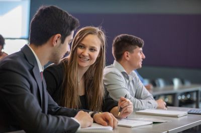 NAU Business students smile while working together in class.