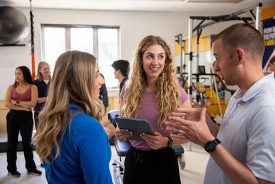 Students smiling in a physical therapy space.