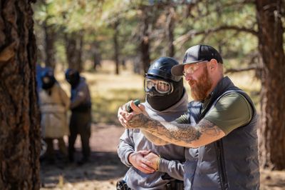 A police officer training a student with a fake gun