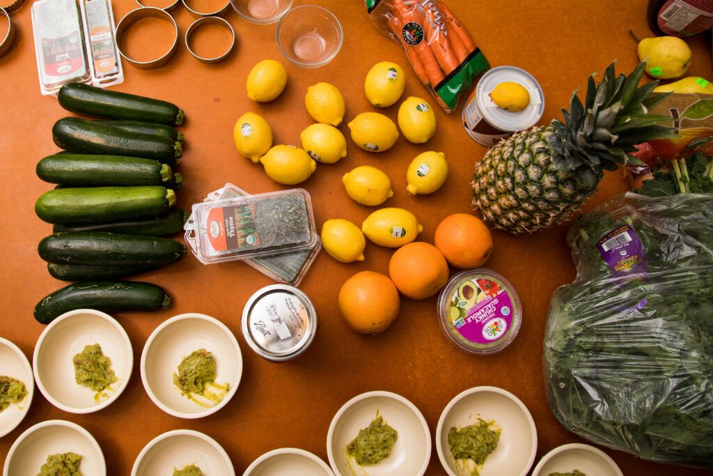 Healthy, nutritious fruits and vegetables including carrots, cucumbers, oranges, lemons, and a pineapple displayed on a table.