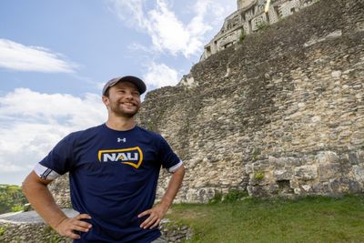 An NAU archaeology student stands proudly while studying in Belize.