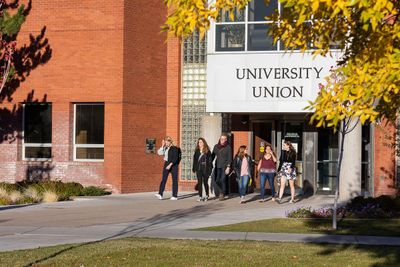 A group of people walk outside a brick building with a "UNIVERSITY UNION" sign.