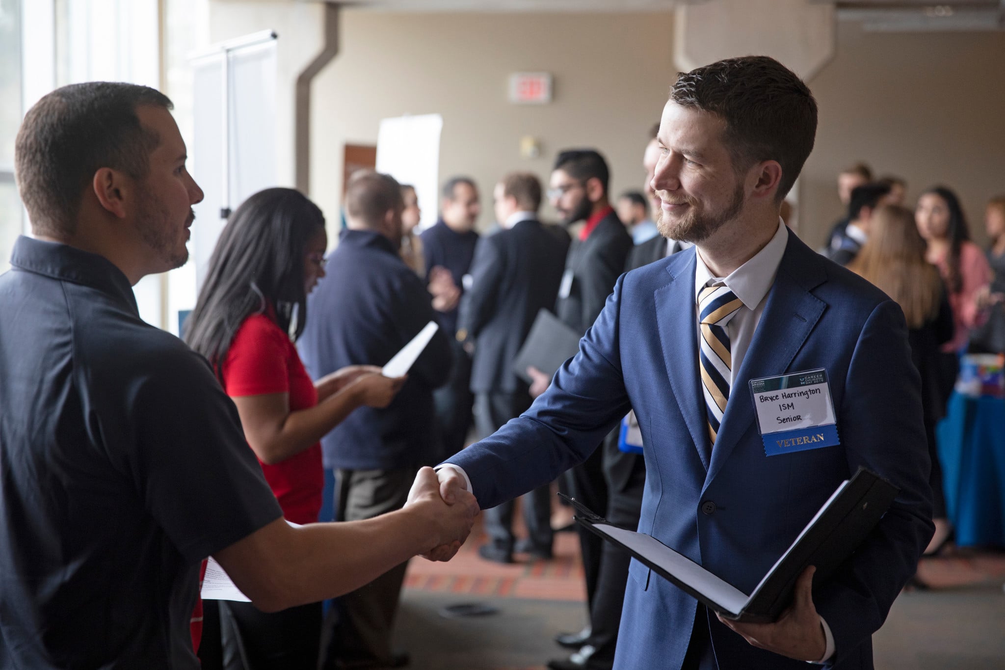 Two men shaking hands at a career and job fair