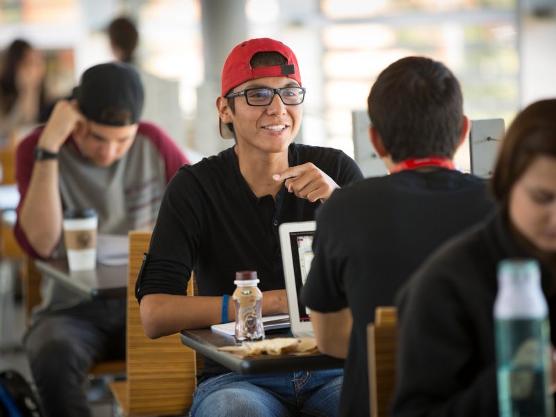 Students sit at tables in University Union and talk.