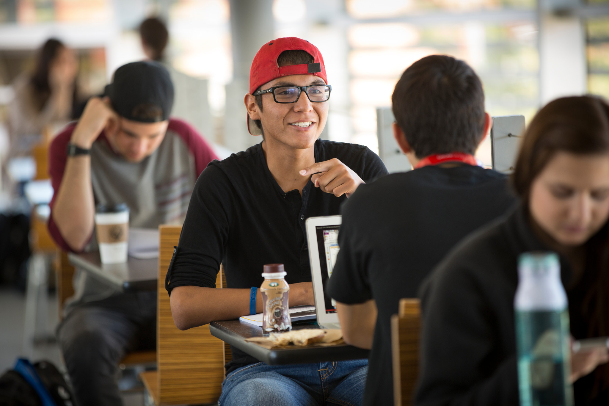Students sit at tables in University Union and talk.