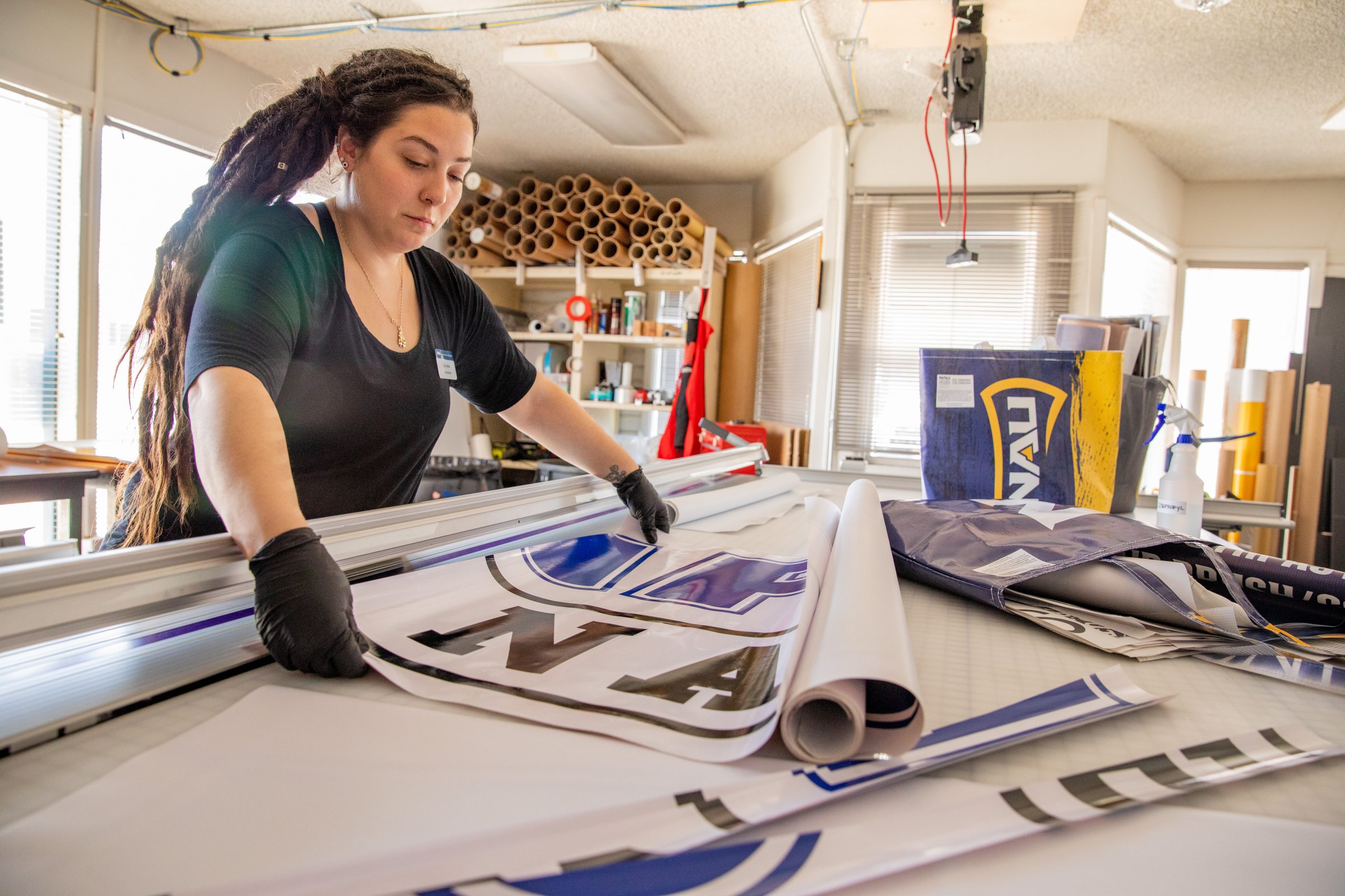 Sara LaRosa works with poster in printing room.