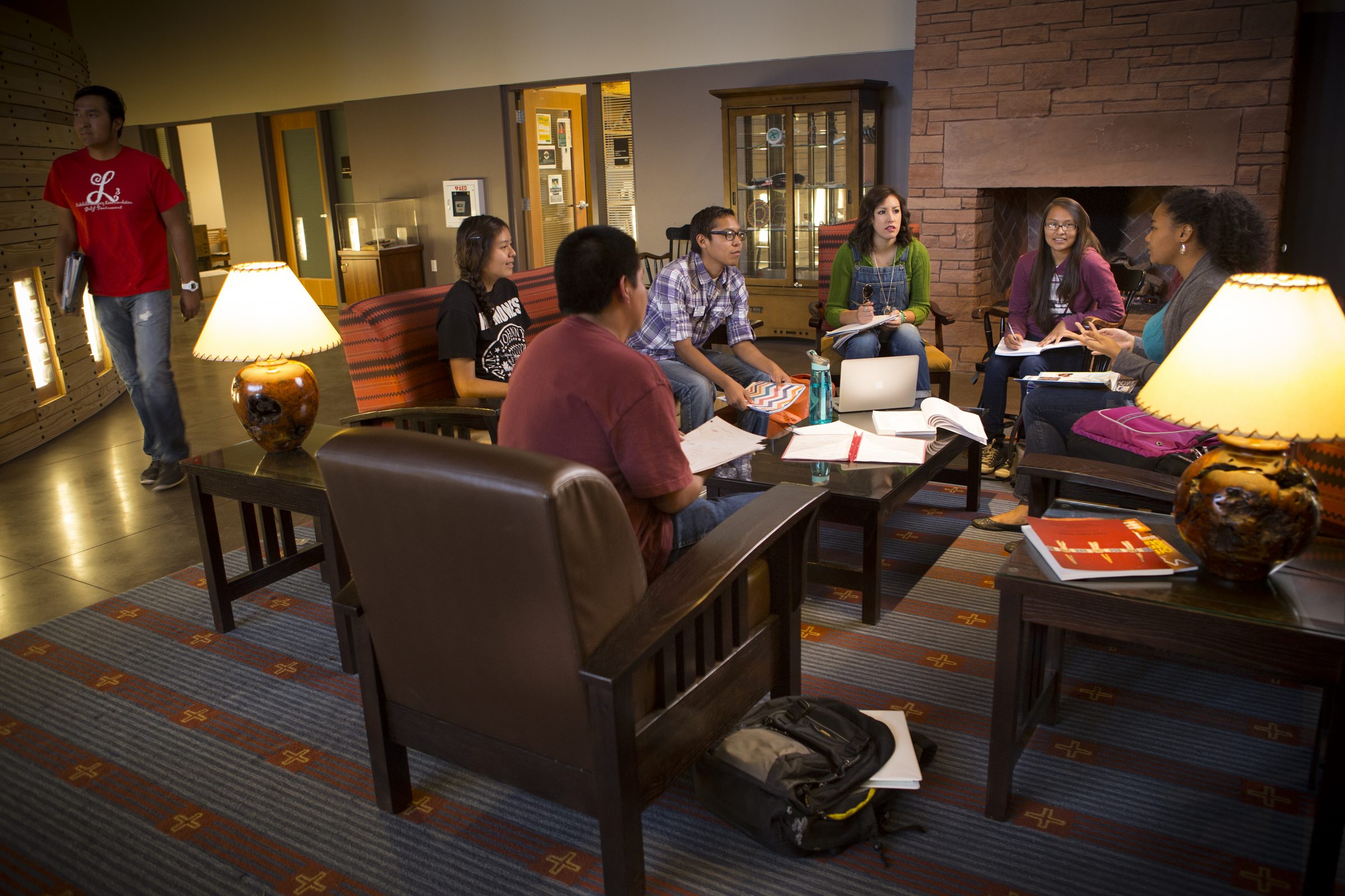 Students sitting in a hotel lobby discussing textbooks.