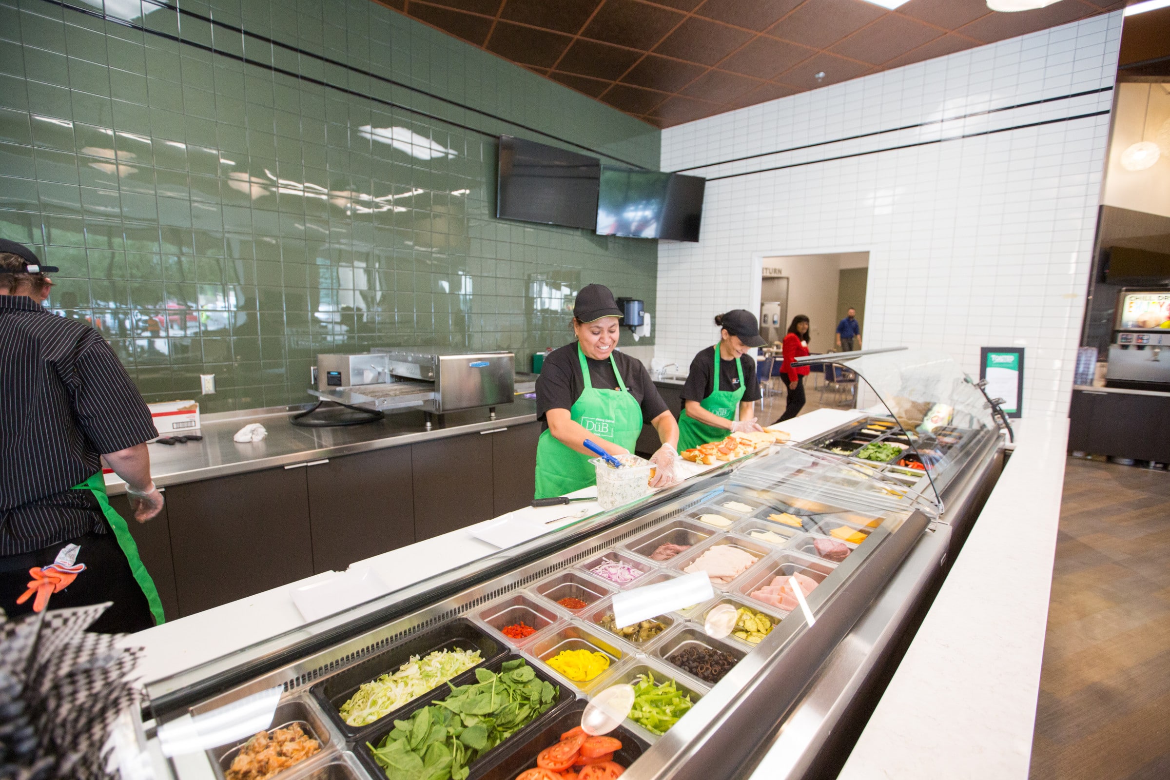 Employees prepare food in buffet dining hall.