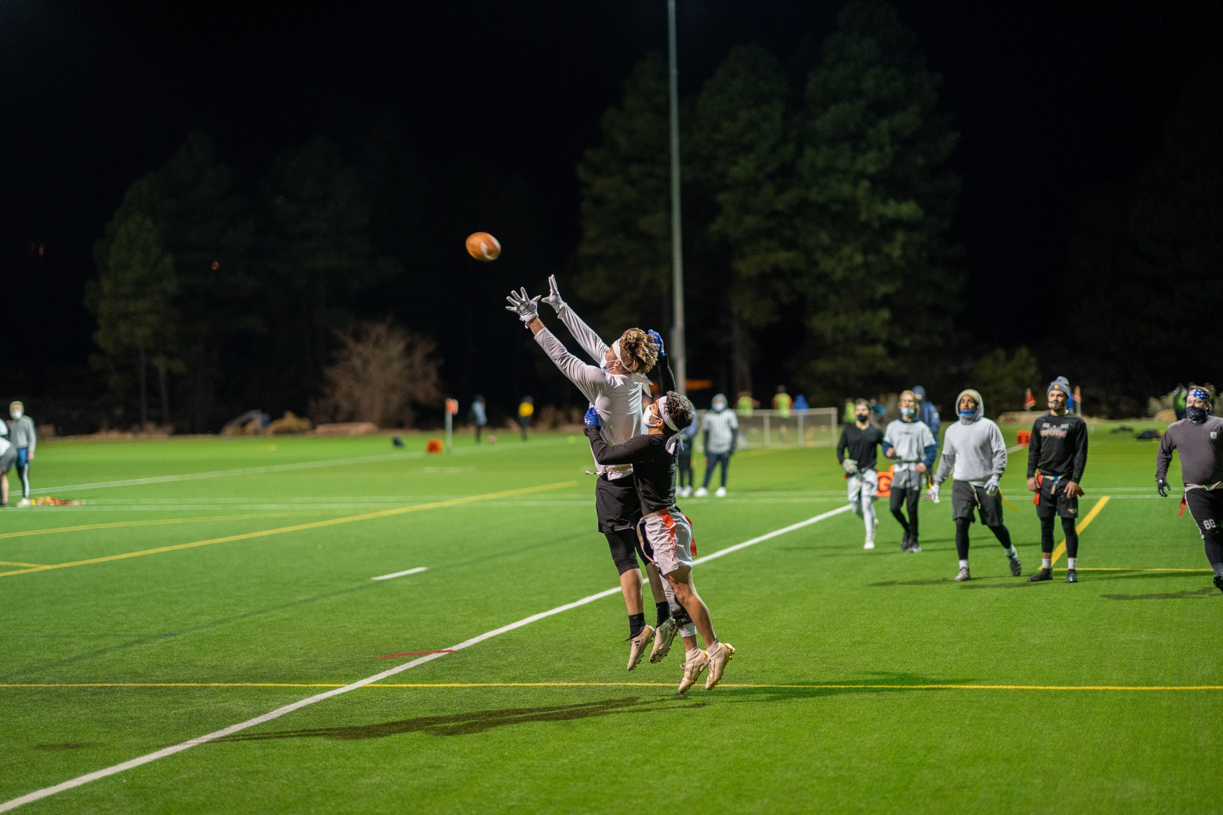 Student jumping in air to catch a football.