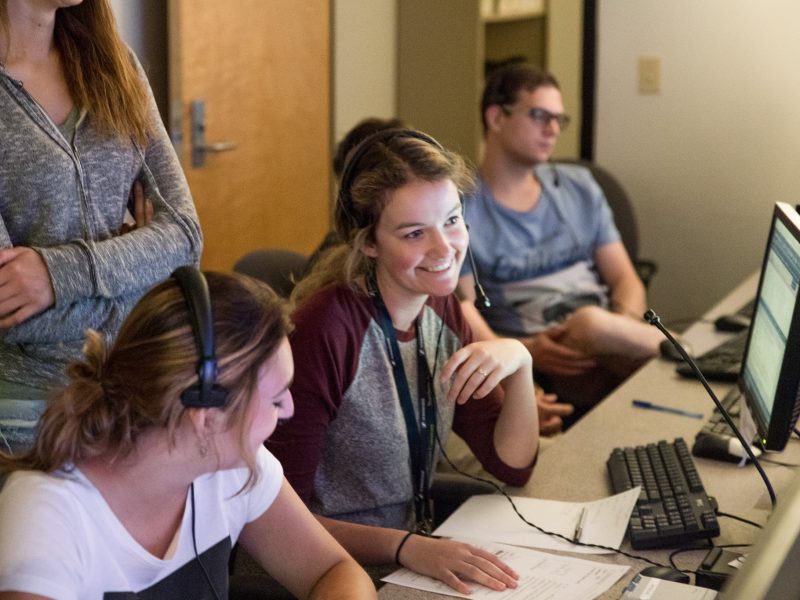 NAU communications students wearing headphones.