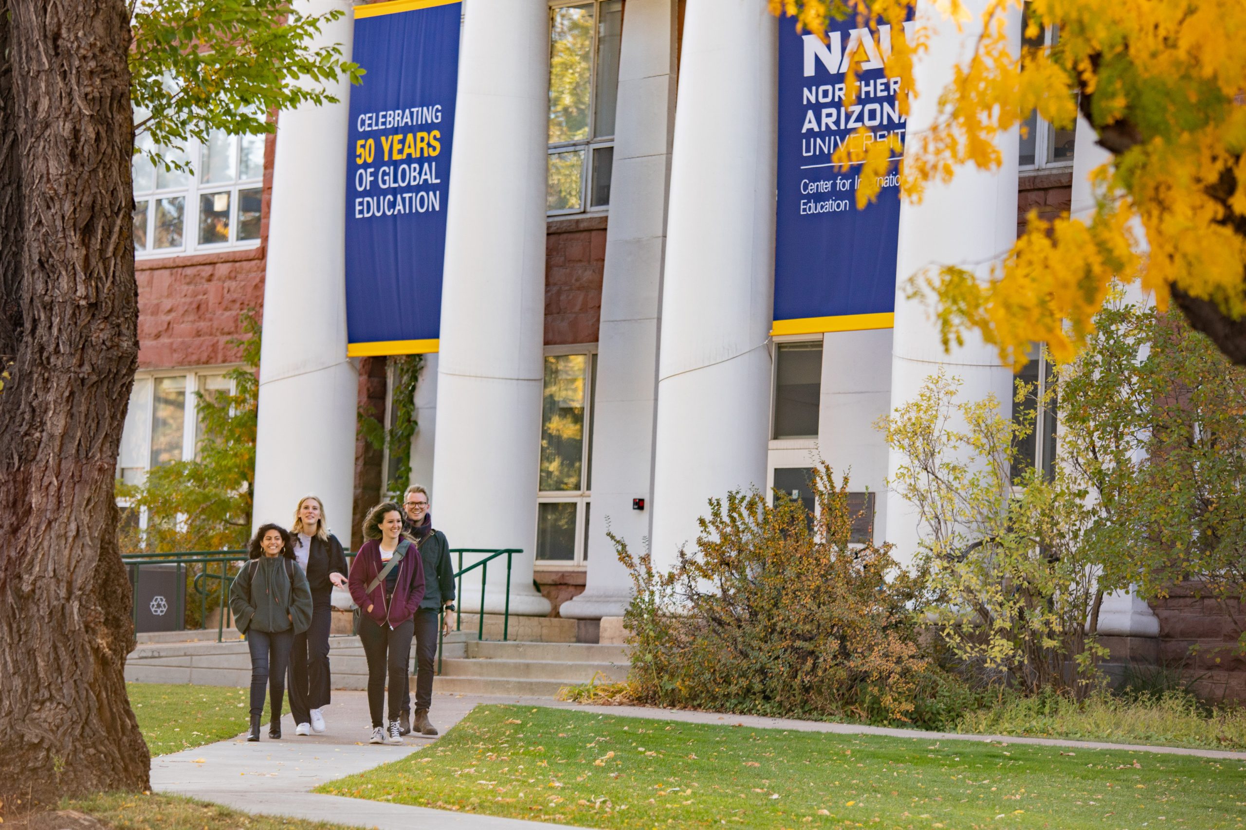 Four students smiling while leaving the 50th anniversary of Global Education at NAU.