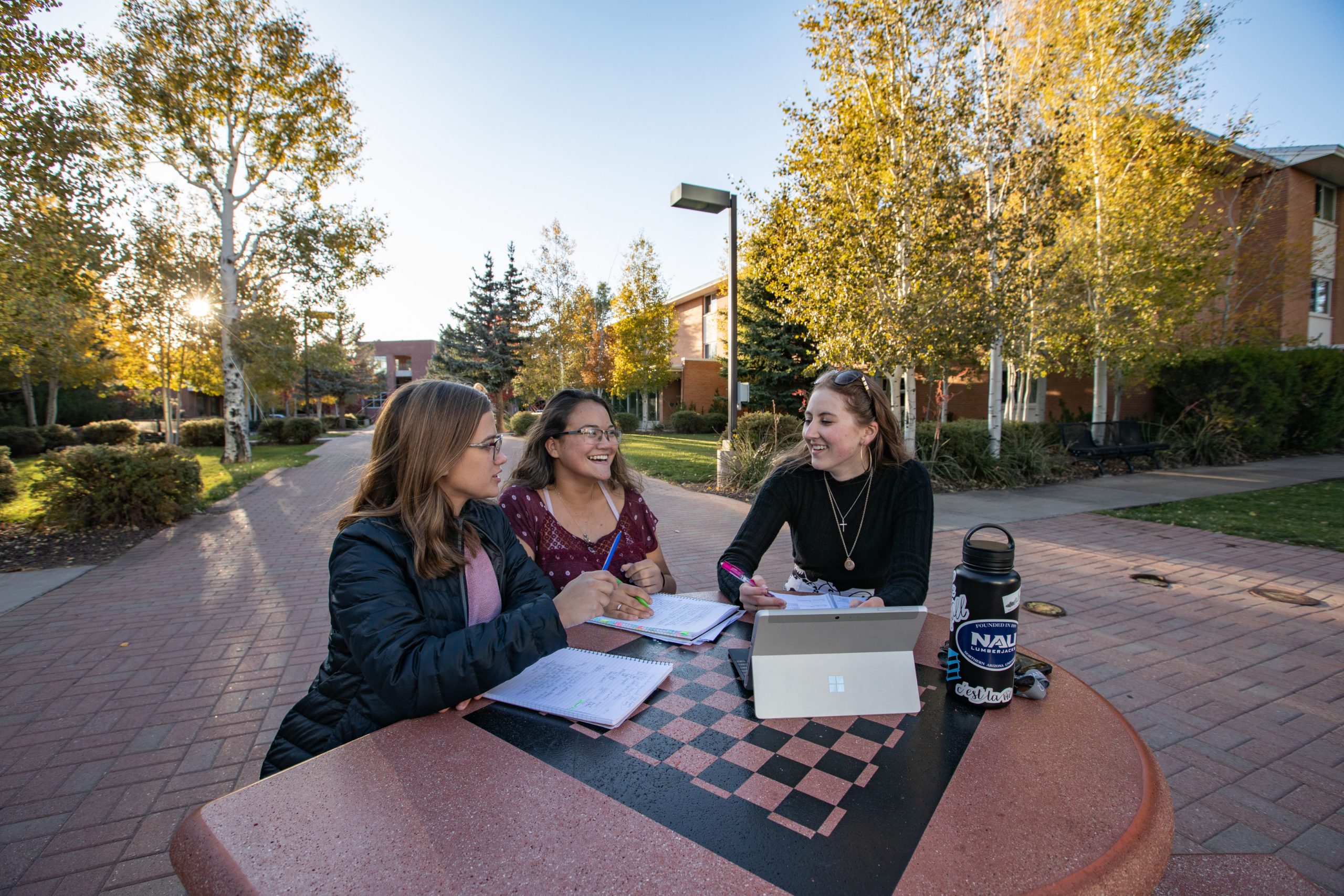 Students studying together outside at checkerboard table.