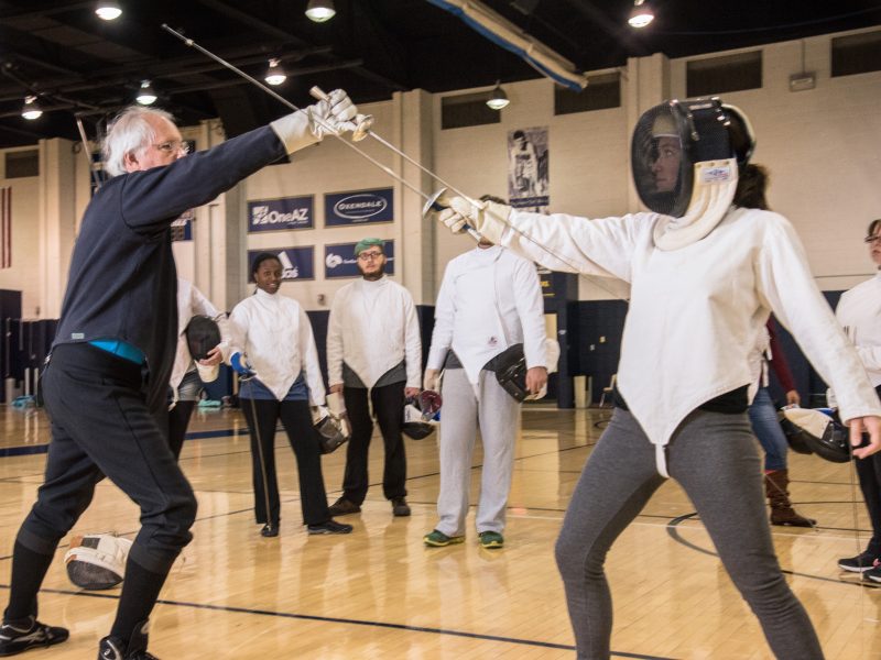 Students fencing in a gym.