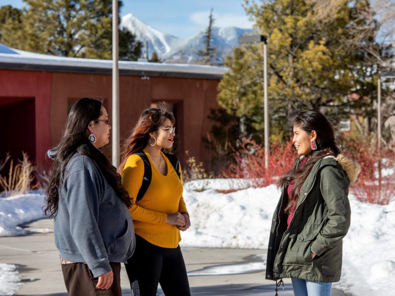 Native American students talk outside of the NAU Native American Cultural Center.