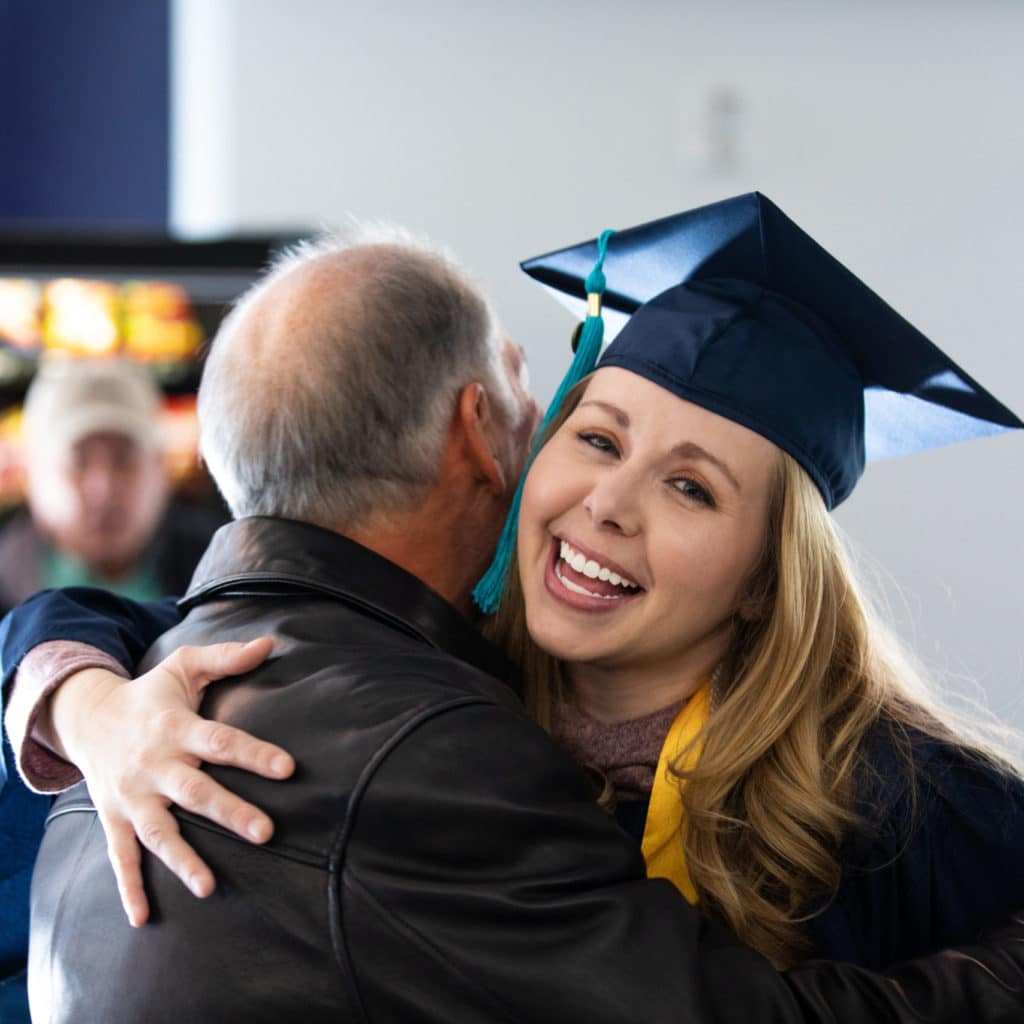 NAU graduate Tiffany Grigsby hugs her family.
