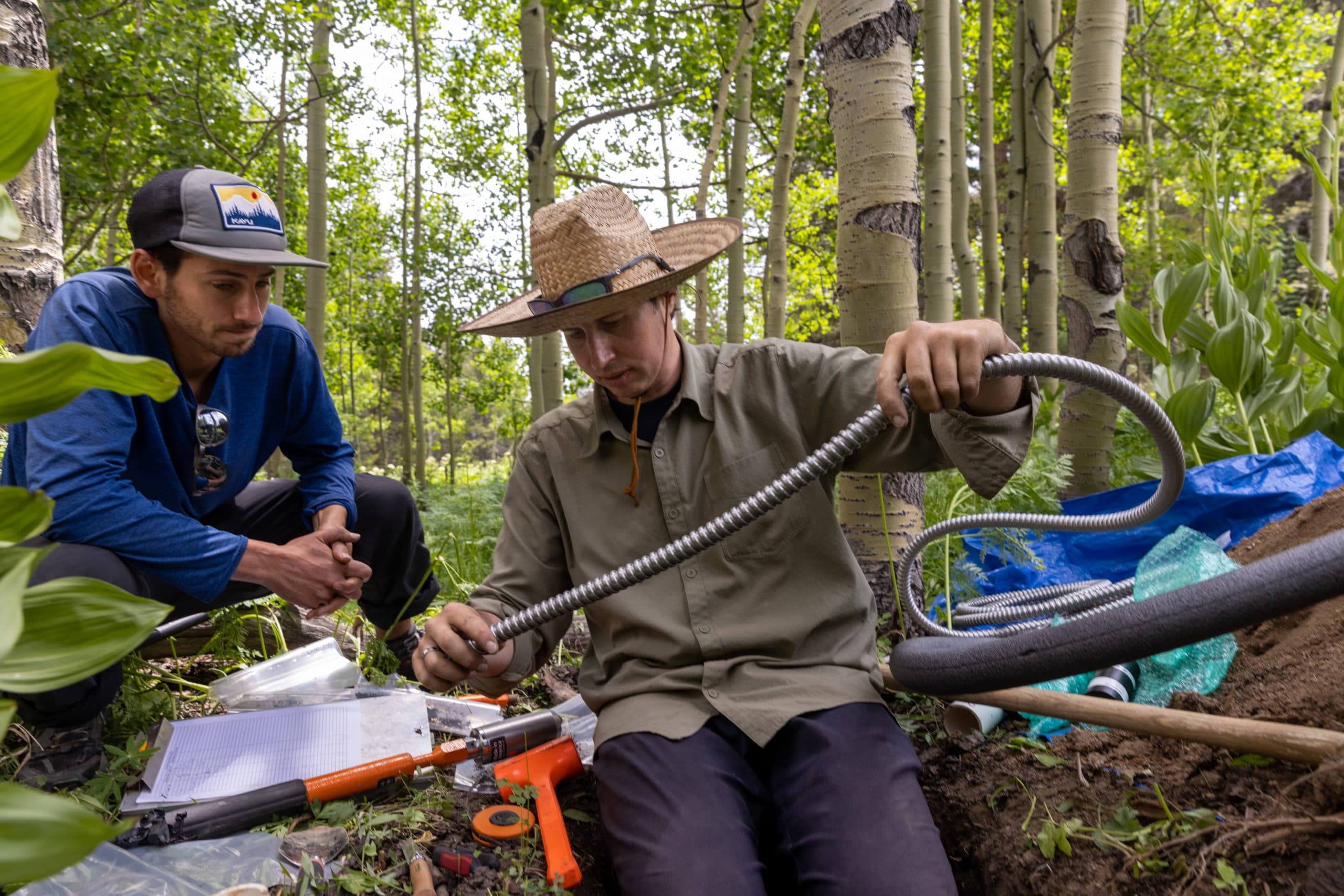Professor and student working on a lab project in the woods.