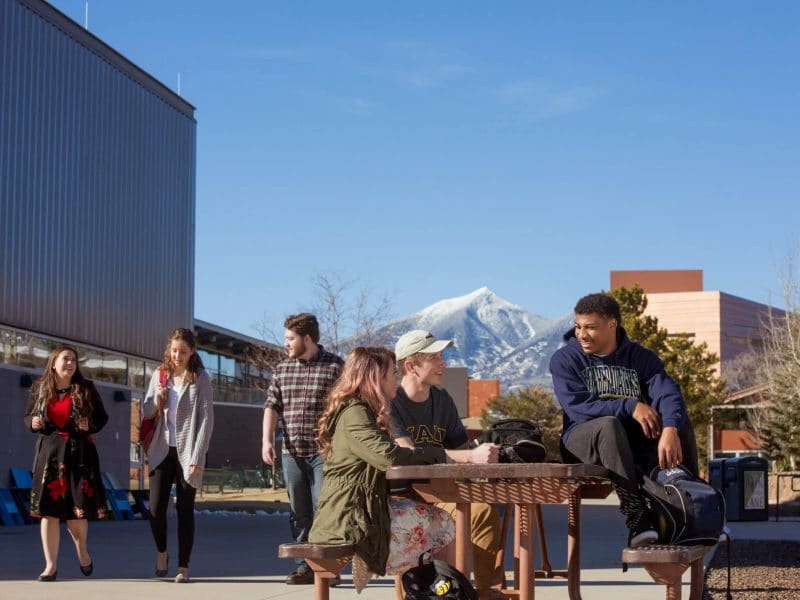 Students sit at picnic table at Flagstaff campus.
