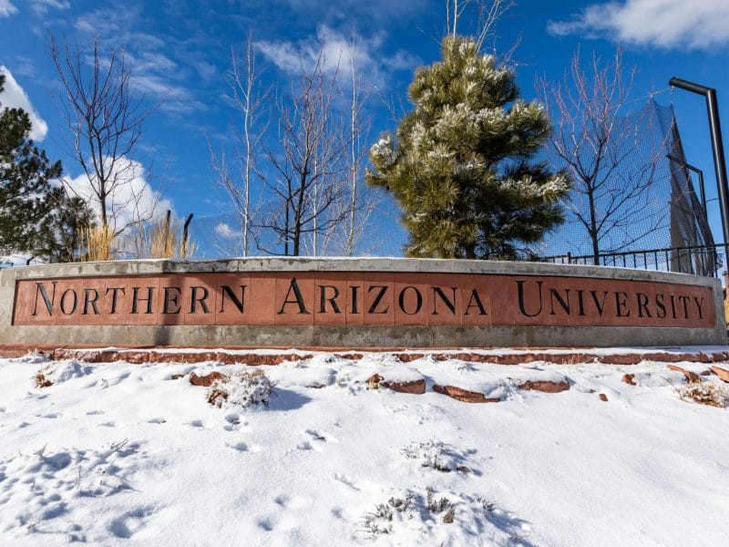 The Northern Arizona University signage surrounded by snow at Flagstaff mountain campus.