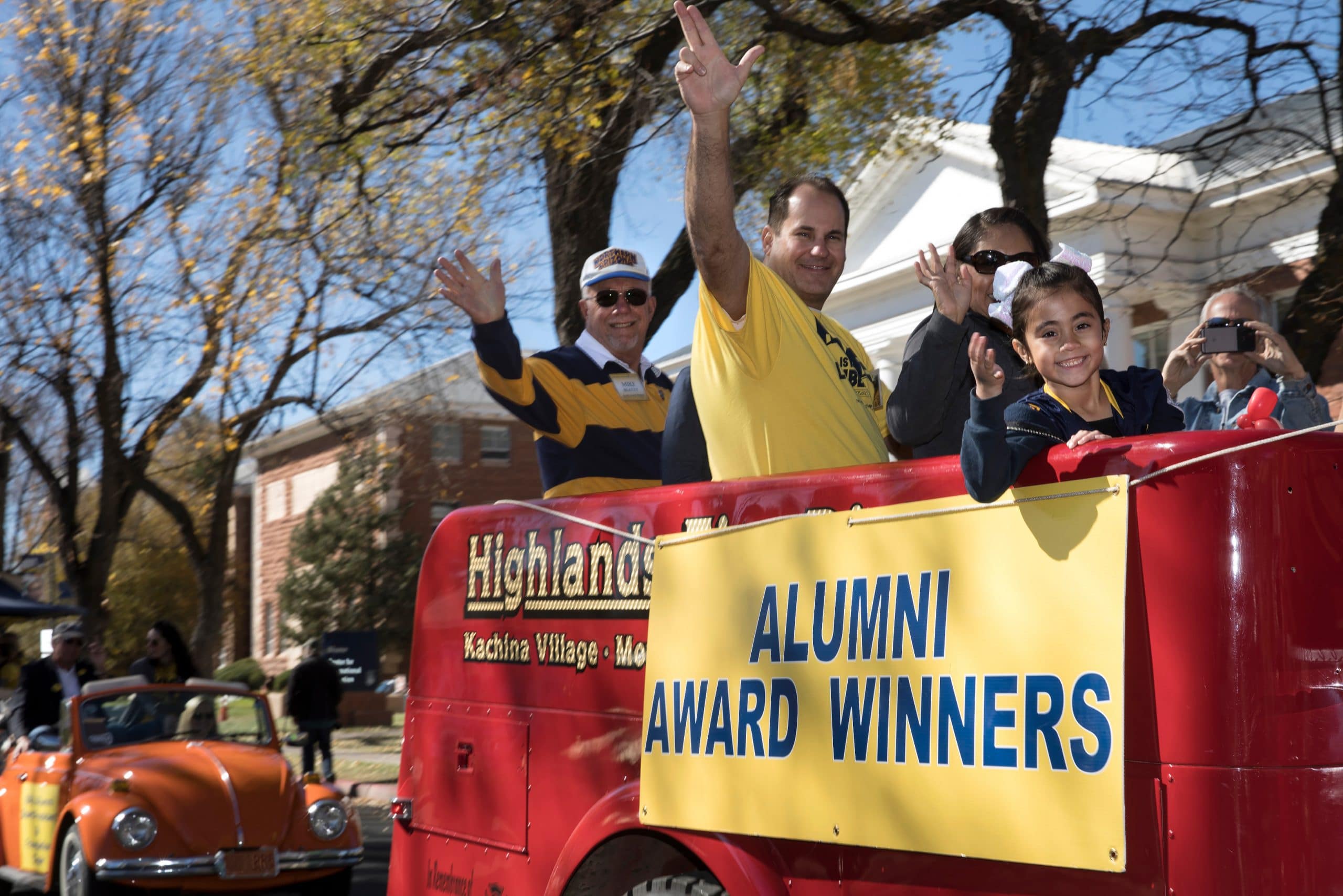Alumni Award Winners waving on parade float.