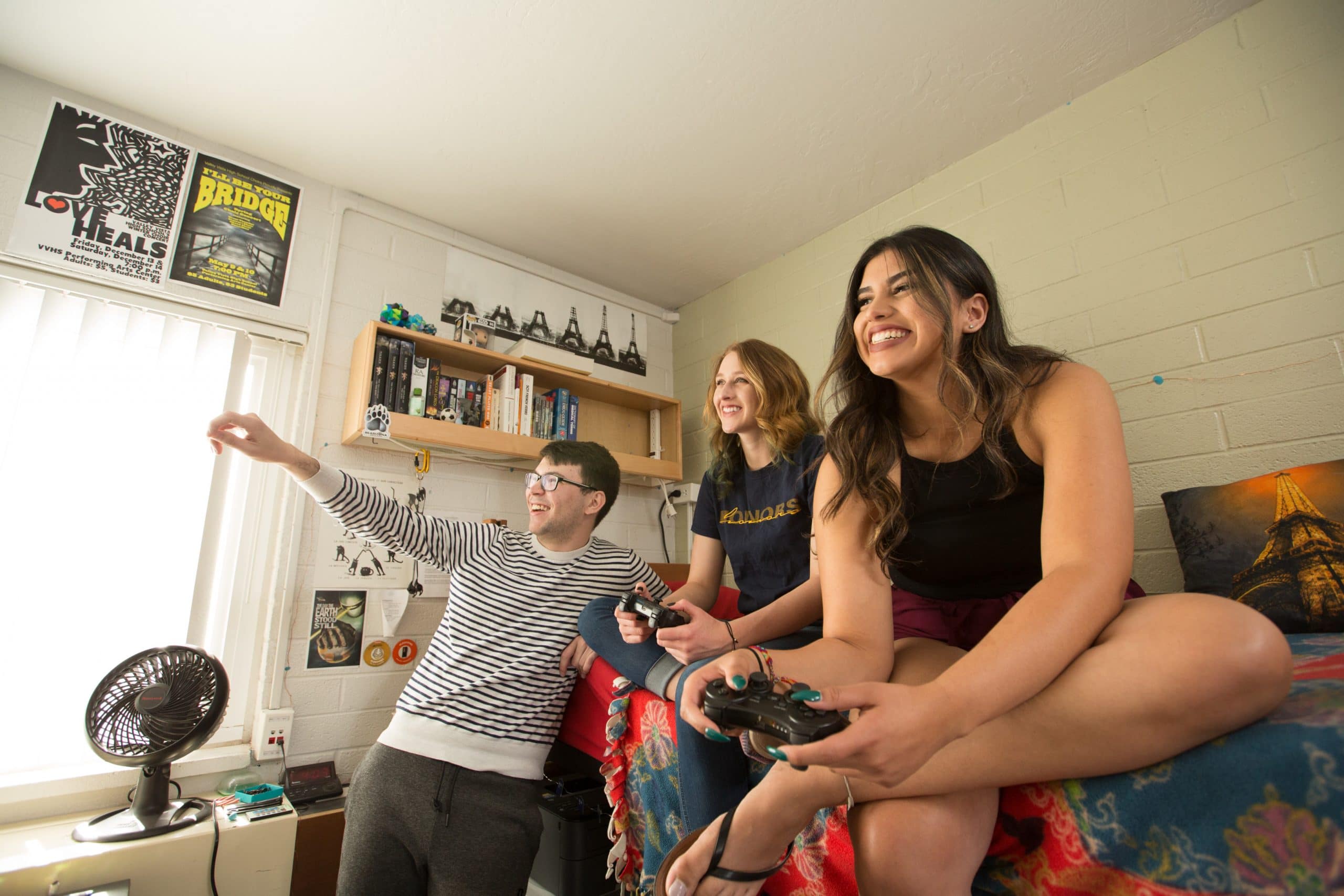 Students playing video games in a dorm room.