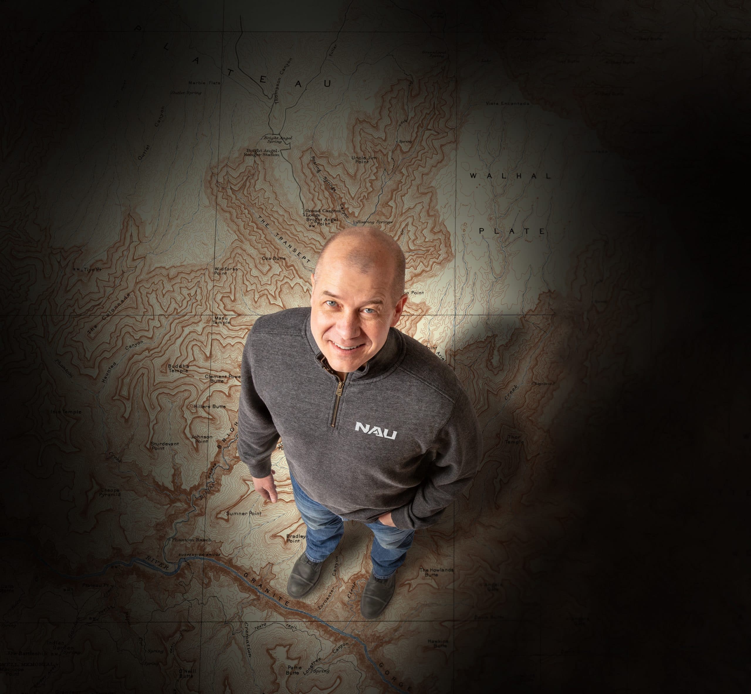 NAU alumni Dave Cook stands superimposed on a map.