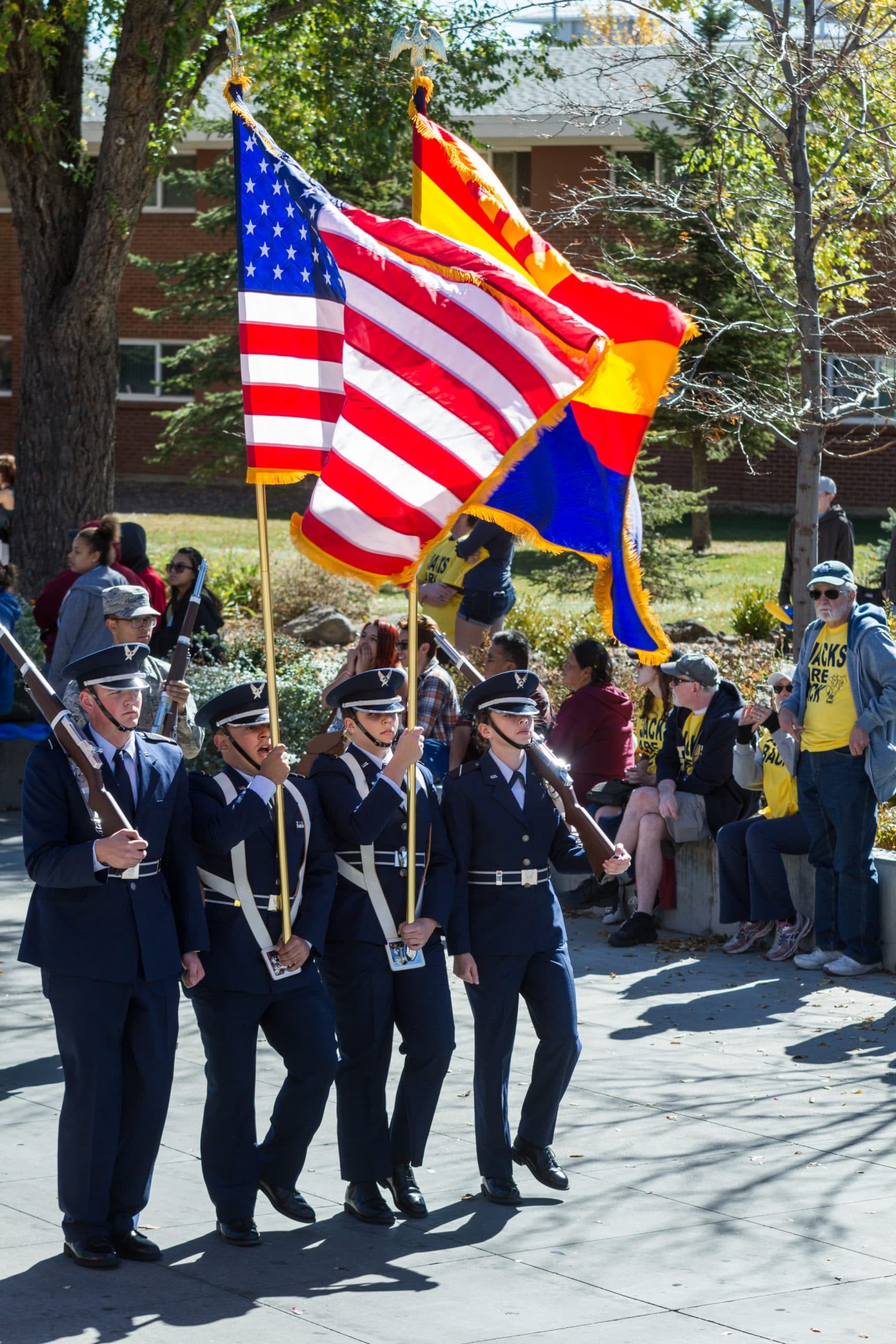 Veteran students march with flags in the homecoming parade.