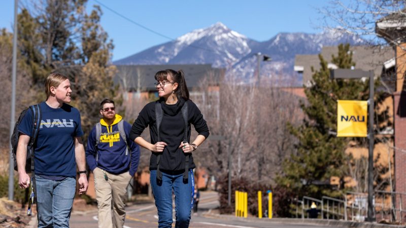 Students with backpacks walk to class at the Flagstaff Mountain Campus.
