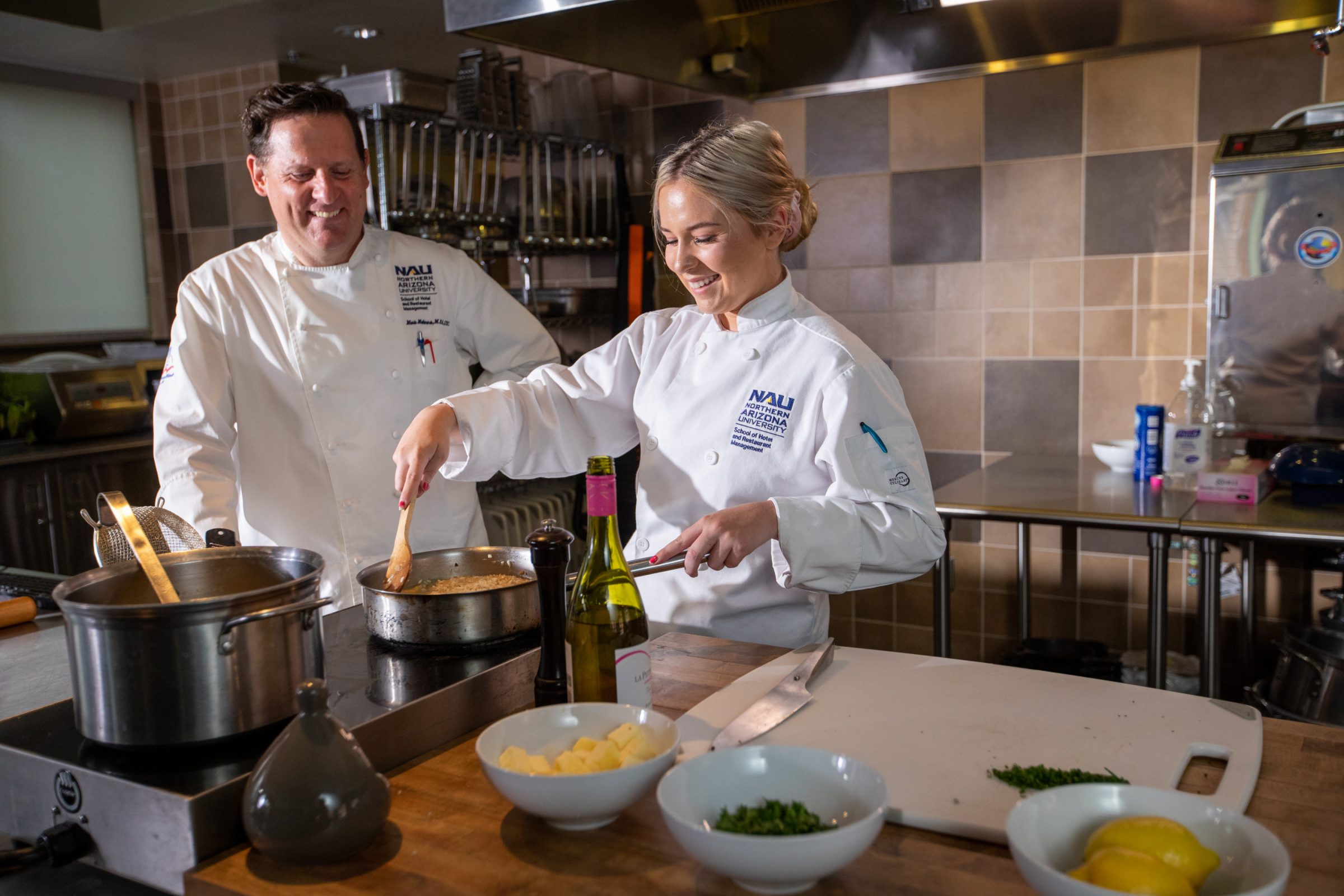 Chef Mark Molinaro teaches an Hotel Restaurant Management student how to cook in the kitchen.