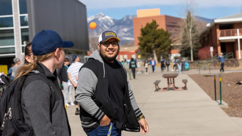 Students smiling and walking through campus.