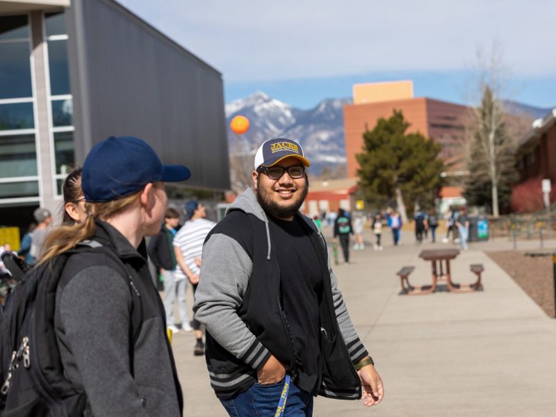 Students smiling and walking through campus.