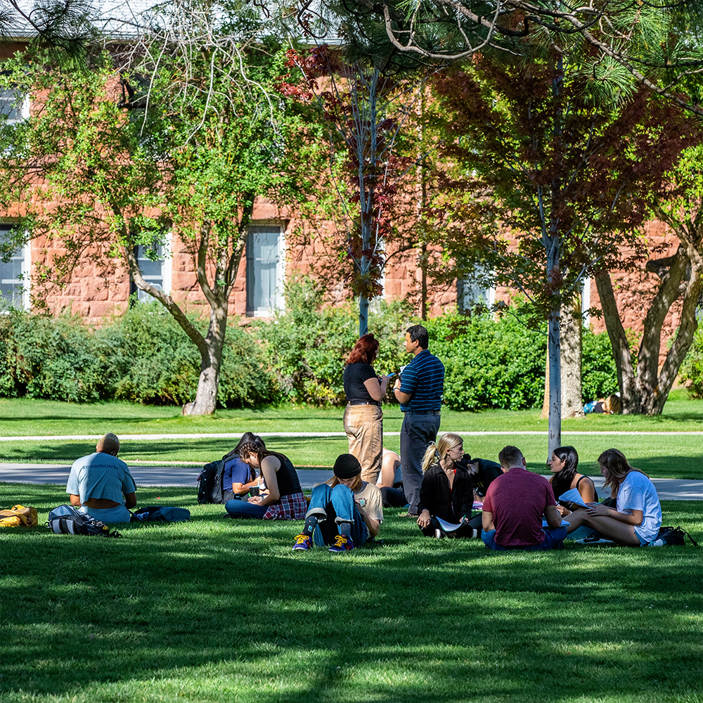 Students sit on outside lawn at NAU Flagstaff mountain campus