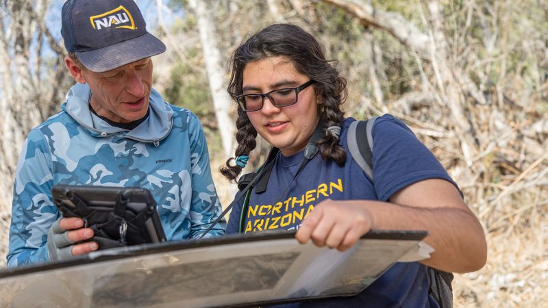 Faculty working with student outdoors