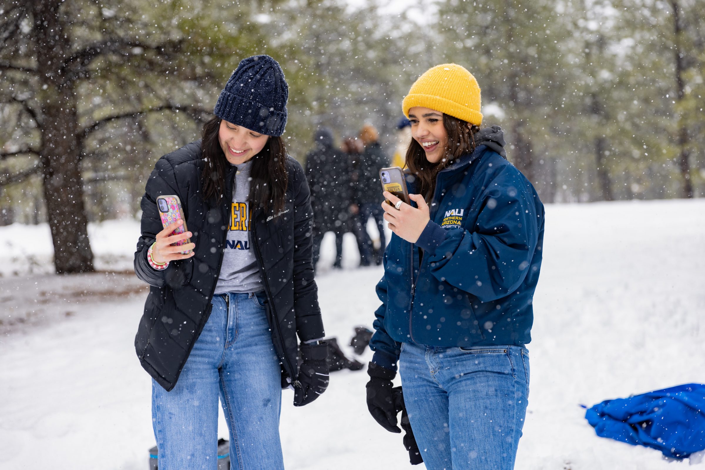 Two students taking pictures out in the snow.