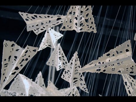 Close up image of lacy paper airplane sculpture by Professor Jennifer Holt