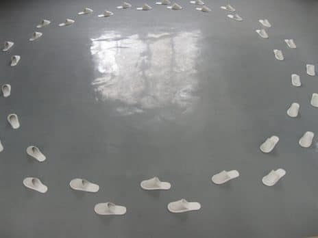 Sculpture of clay slippers organized in a circle, entitled Quiet, by Professor Jennifer Holt