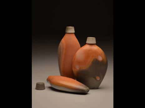 Collection of orange and brown flasks with lids by student Duncan Tweed
