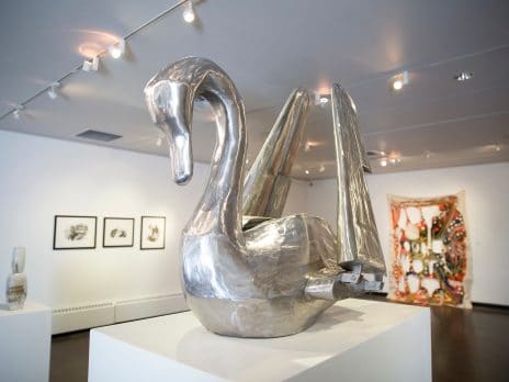 a metal swan with hinged wings in a gallery