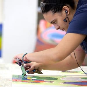 a female art student works on a painting