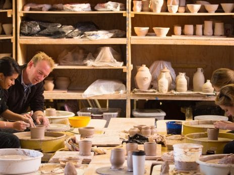 a group of students works in a pottery studio