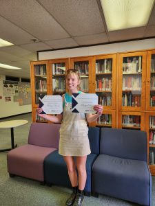 CCS major Morgan Wood poses with her two scholarship certificates.