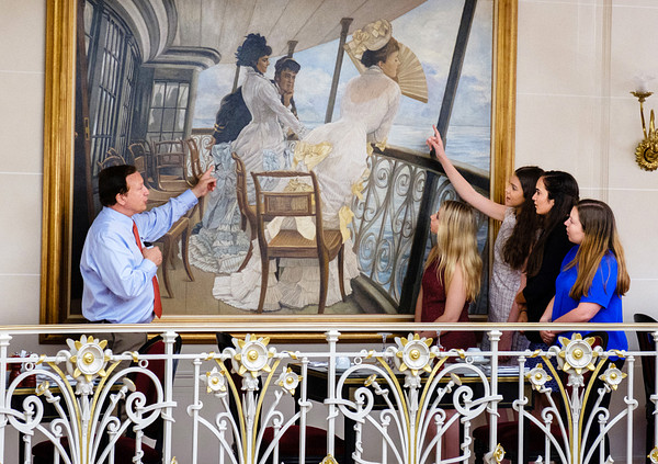 N A U study abroad students viewing a painting displayed in a museum.