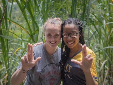 two students posing with the lumberjack hand sign