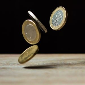 Four coins falling onto a table.