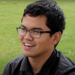 NAU student with glasses smiling.
