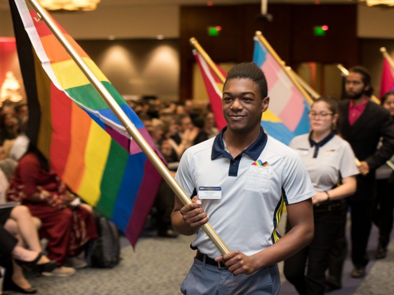 Students lined up with different symbolic flags at a diversity event.