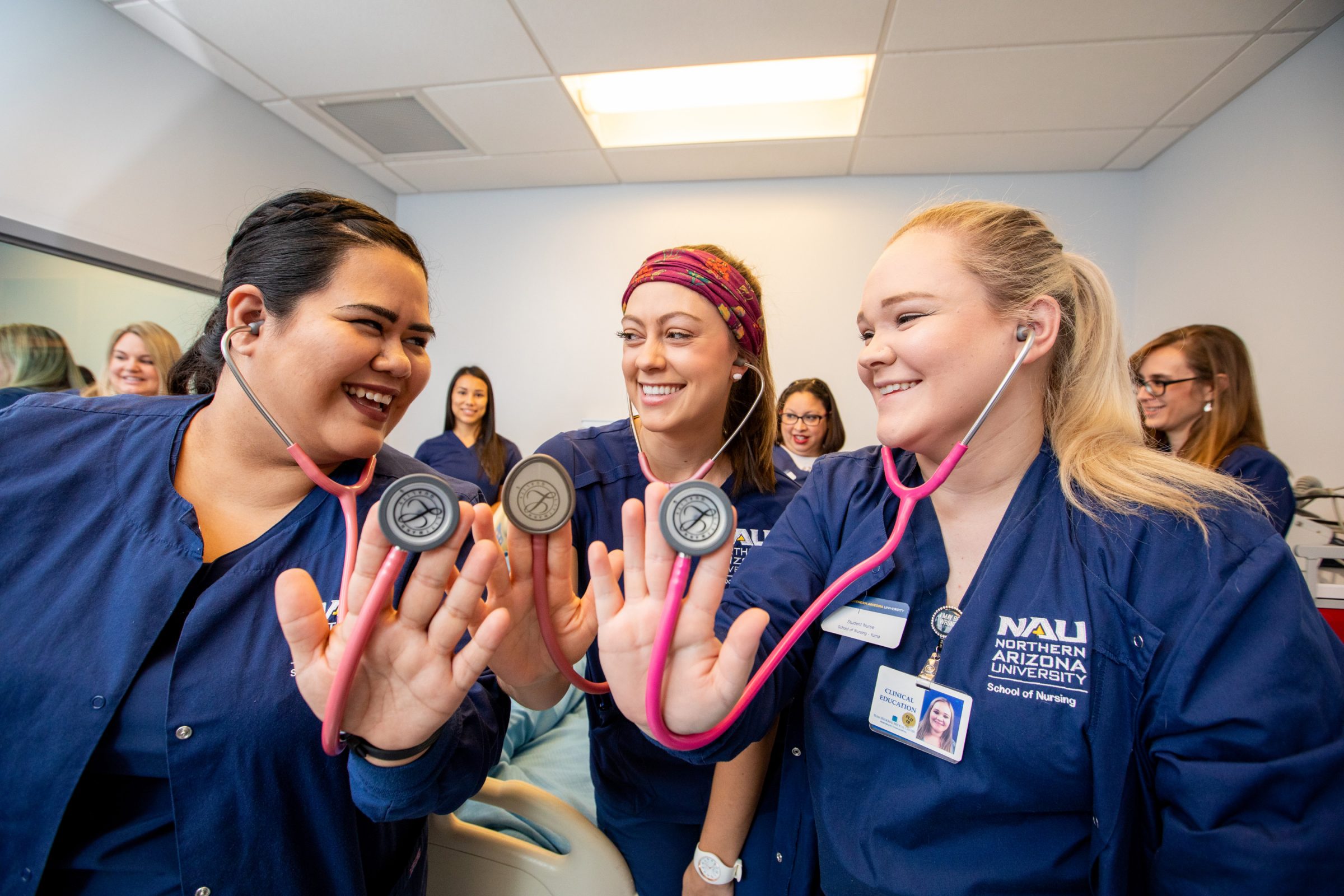 N A U nursing students hold up their stethoscopes.